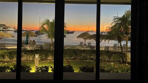 A view from a room with large windows overlooking a marina at sunset. - Amazing Beachfront Condo in Simpson Bay -Walk Out Beach/Pool (Philipsburg)