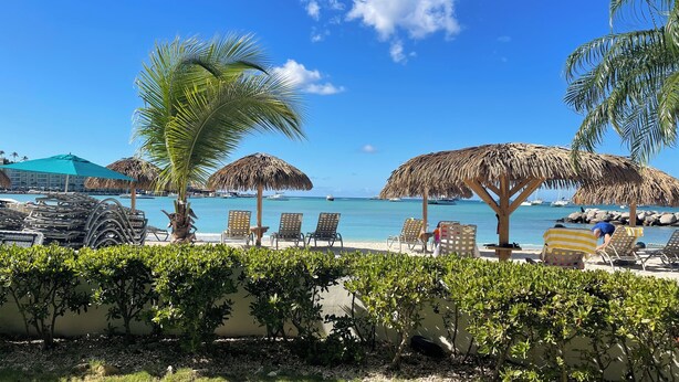 A beachside resort with lounge chairs, thatched umbrellas, and a pool area. - Amazing Beachfront Condo in Simpson Bay -Walk Out Beach/Pool (Philipsburg)