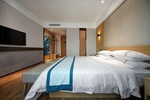 Une chambre d’hôtel avec un lit, une banquette, un téléviseur et une lampe fixée au mur.