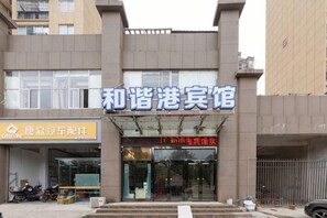 A building with a sign reading '和谐港宾馆' and another sign for '康众汽车租赁'. - Harmony Harbour Hotel (Sixin Avenue Subway Station Hancheng Garden ) (Wuhan)