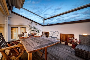 An outdoor patio with a wooden table, chairs, and potted plants. - YiD luxury & Design penthouse L5 (Firenze)