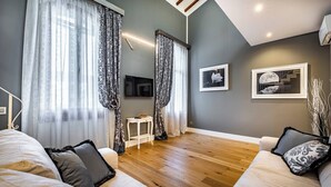 Ein modernes Wohnzimmer mit einer Sofagarnitur, einem kleinen Tisch und einem Fernseher.