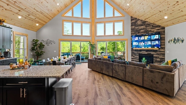 A spacious kitchen with a large island, a dining area with outdoor seating, and a living area with a fireplace. - Emerald Escape - Managed by Gr8Escapes (Massanutten)