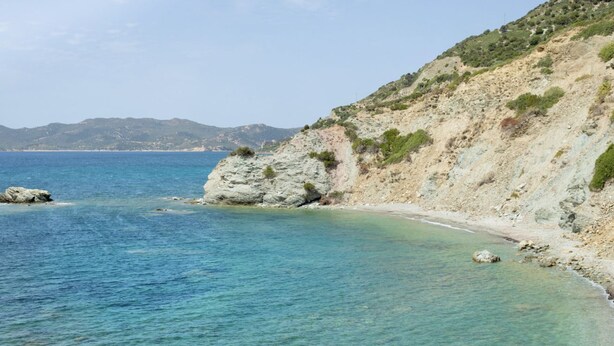A coastal landscape with clear blue waters, rocky cliffs, and a sandy beach. - Two-room apartment of approximately 42 m2 with air conditioning composed of a living room with TV, foldaway bed and single sofa bed, kitchenette equipped with electric hobs and fridge.Bedroom with double bed, bathroom with shower and hairdryer, shaded ve (Teulada)