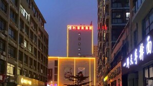 A multi-story building with illuminated signage and a clear sky. - Xikelai Hostel (Yantai)