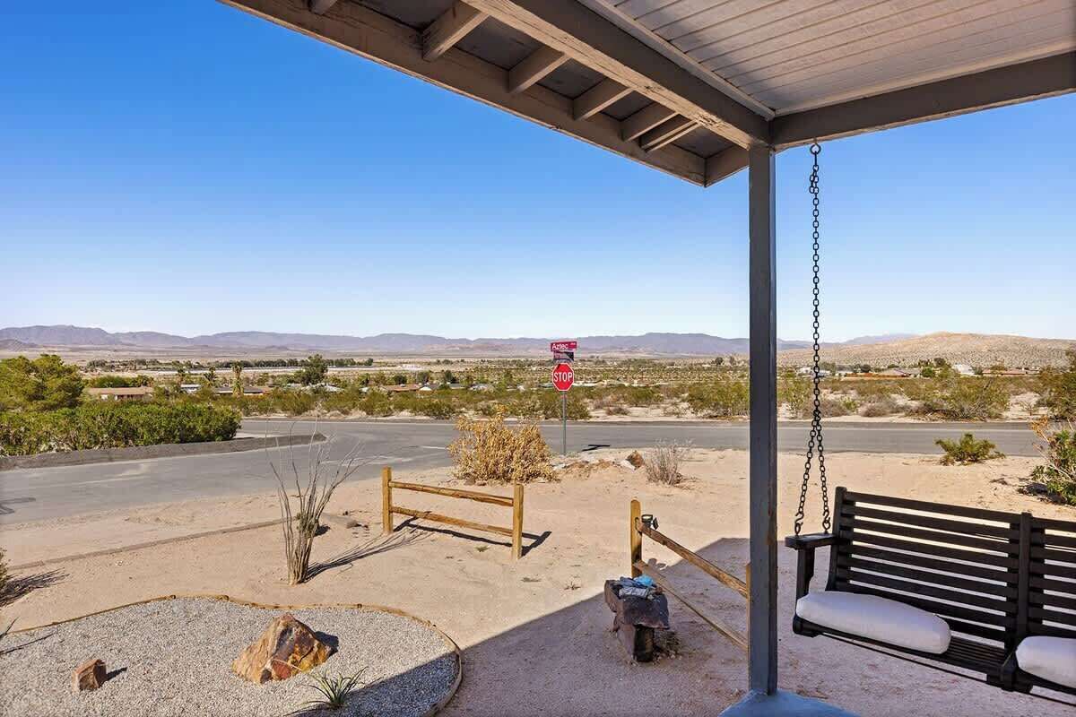 Un espacio al aire libre techado con una hamaca, una señal de stop y vistas a un paisaje desértico.