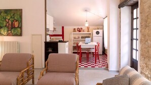 A living room with striped sofas, a dining area with a checkered floor, and a kitchen with a refrigerator and a laptop on the table. - S339 - Sirolo, wonderful three-room apartment surrounded by nature (Sirolo)