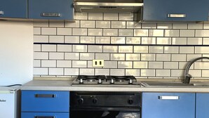 A kitchen with blue cabinets, a gas stove, and a built-in oven. - Palme 4 - Marcelli, one-room apartment on the ground floor, Residence Le Palme (Marcelli)