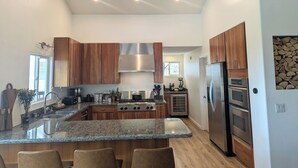 Une cuisine moderne avec des meubles en bois, des appareils en acier inoxydable et un plan de travail en granit.
