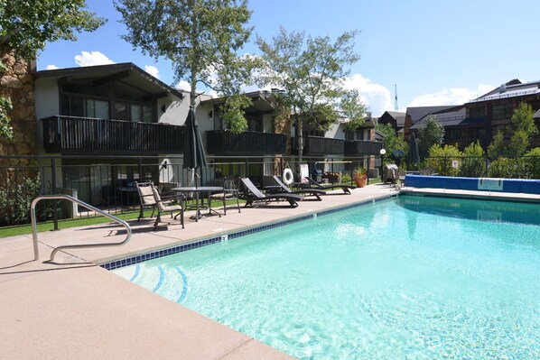 A swimming pool with lounge chairs and a safety railing.