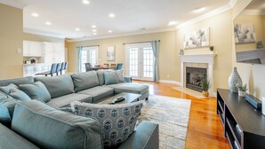 A spacious living room with a large sectional sofa, a fireplace, and a dining area in the background. - Chattanooga Valley Paradise | Pickleball | Pool (flintstone)