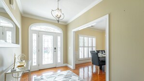 A spacious hallway with a chandelier, a dining area with a table set for four, and a patterned rug on the floor. - Chattanooga Valley Paradise | Pickleball | Pool (flintstone)