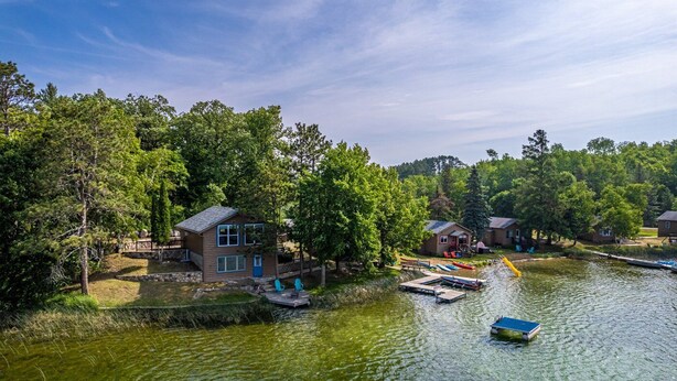 A lakeside property with multiple cabins, docked boats, and a small dock area. - Cabin #6 - Loons' Nest (Lake Emma Township)