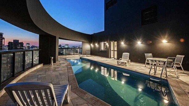 A rooftop pool area with a clear view of the city skyline at dusk. - Flat com Cozinha Completa em Hotel Slaviero em Moema (Indianópolis São Paulo)