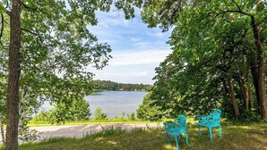 A lakeside view with two turquoise chairs facing the water. - Cabin #7 - Gone Fishing (Lake Emma Township)
