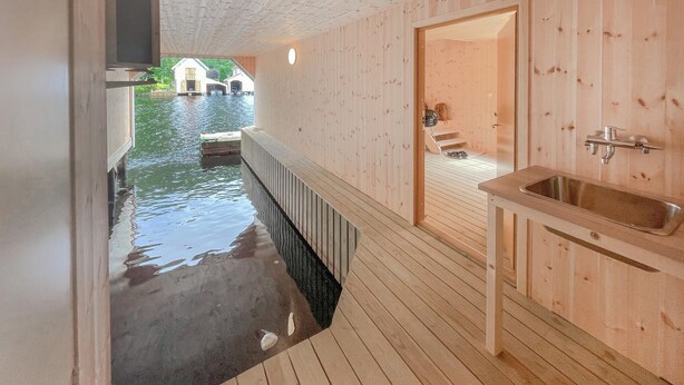 Une cabane en bois dotée d’une petite terrasse extérieure et d’un évier intégré.