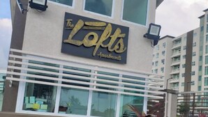 A building with a sign reading "The Lofts Apartments."