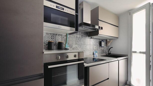 Eine moderne Küche mit Backofen, Mikrowelle und Gasherd.