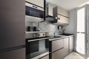 A modern kitchen with a built-in oven, a microwave, and a gas stove.