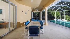 A covered outdoor area with a pool, a table with chairs, and a ceiling fan. - Sand Castle - close to beaches, shopping (Englewood)
