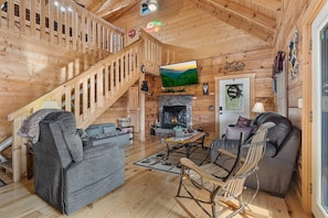 A wooden interior with a fireplace, a staircase, and a sofa. - Hot Tub ~ Pool Table ~ Wifi ~ Secluded ~ Multicade (Sevierville)