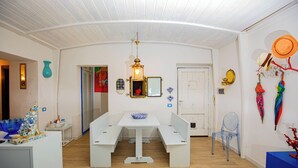 A room with a white bench table, a hanging lantern, and a door with a mirror. - 50 steps from the Mare Superior (Orbetello)