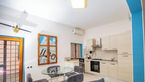 Un apartamento moderno con comedor, cocina y puerta corrediza de vidrio que da a un balcón.