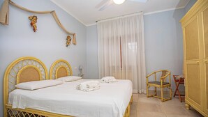 A room with a bed, a chair, a wardrobe, and a ceiling fan. - Seaside apartment in Bengodi (Fonteblanda)