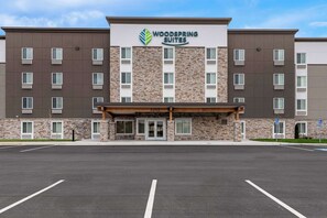 A multi-story hotel with a stone facade and a sign reading "Woodspring Suites." - Woodspring Suites Kansas City Airport (Kansas City)