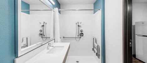 A modern bathroom with two sinks, a shower, and a toilet.