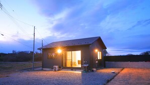 Un petit bâtiment d’un seul étage, doté d’un toit en pente, d’une porte d’entrée et d’un espace intérieur visible.