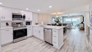 A modern kitchen with white cabinetry, stainless steel appliances, and a central island. - Seagate 307—Oceanfront Condo w/ Gulf Balcony, Pool Access & Walkable Dining in Indian Shores (Indian Shores)