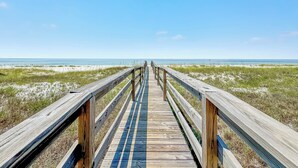A wooden boardwalk leading to a beach with a clear blue sky. - "Sandy Feet Retreat" | Beachfront | Private Pool | Beach Getaways (Pensacola)