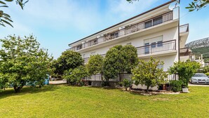 A multi-story residential building with balconies, surrounded by well-maintained lawns and trees. - 1 bedroom awesome apartment in Kastel Kambelovac (Kastel Kambelovac)