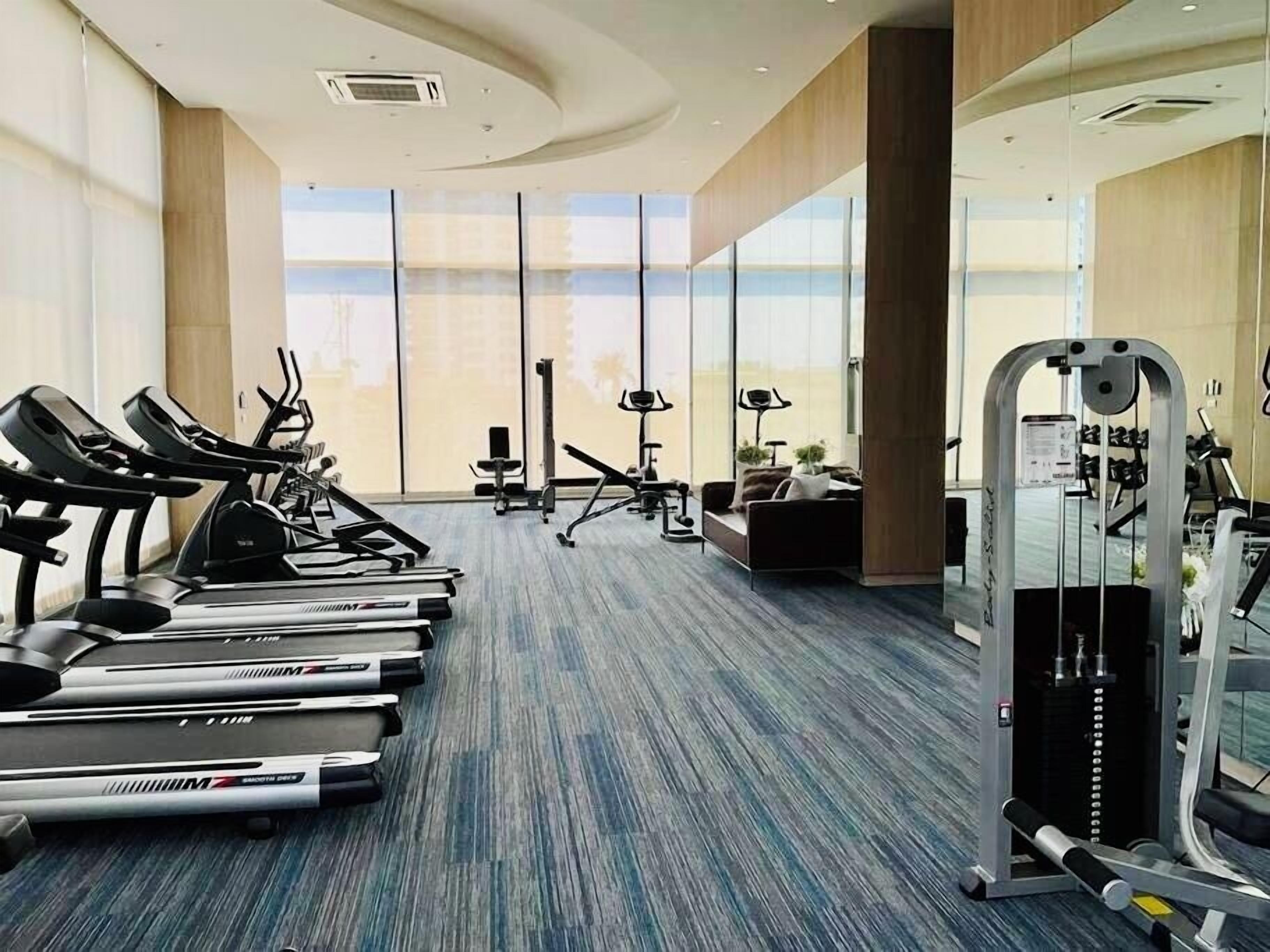 A gym with treadmills, stationary bikes, and weight machines.