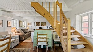 A cozy room with a wooden staircase, a green dresser, a sofa, and a patterned rug. - 4 bedroom gorgeous home in Rødby (Rødby)
