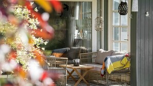 A cozy outdoor seating area with wicker furniture and a table, a hanging lantern, and a door with a window. - 3 bedroom awesome home in Vig (Vig)