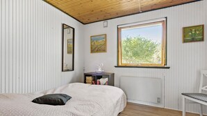 A bedroom with a bed, a desk, a chair, a window, and artwork on the walls. - 3 bedroom awesome home in Vig (Vig)