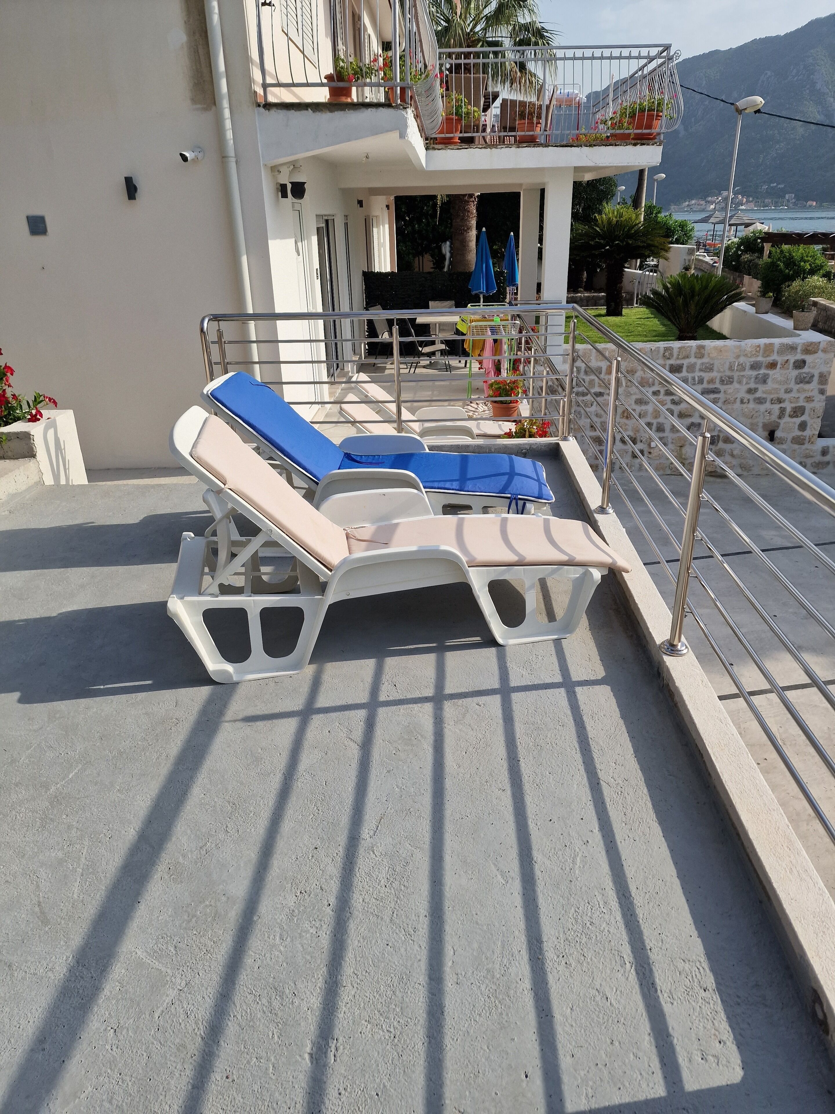 A poolside area with sun loungers and a stone wall.