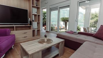 Superior appartement, uitzicht op zee | Woonruimte | Een 44-inch ledtelevisie met kabelzenders