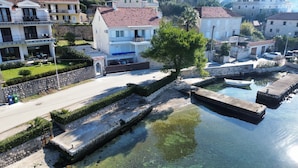 Ein Küstenwohngebiet mit Steinmauern und freiem Blick auf das Wasser.