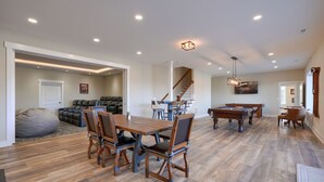 A spacious living area with a pool table, a dining table with chairs, and a large bean bag chair. - Heavenly View | Hocking Hills, Pool, Theater (Logan)