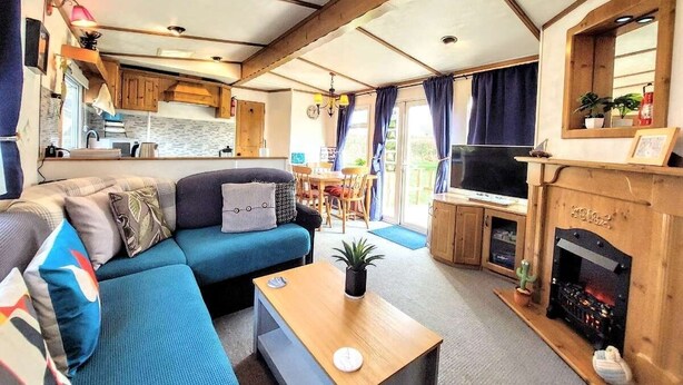 Un interior de autocaravana acogedor, con sala de estar, cocina y chimenea.