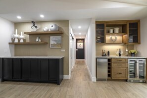 Modern kitchen with central island, dark cabinetry, and appliances.