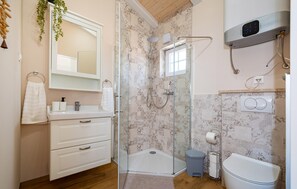 A modern bathroom with a glass-enclosed shower, a white sink with a mirror above, and a toilet with a bidet attachment. - Nice home in Rovanjska (Rovanjska)