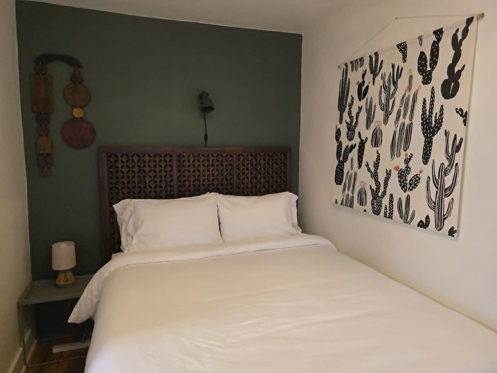Cozy bedroom with stylish accent wall, carved headboard, and crisp linens