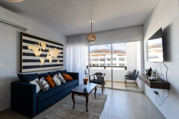 Una sala de estar moderna con un sofá azul, una mesa de centro y una obra de arte con un mapa del mundo.