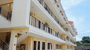 A multi-story building with balconies, staircases, and a flat roof. - Maple Residences (Talisay)