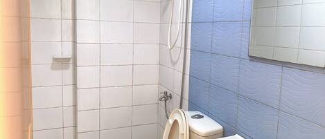 A bathroom with a toilet, sink, and shower.