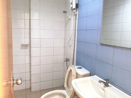 Un baño con inodoro, lavabo y ducha.